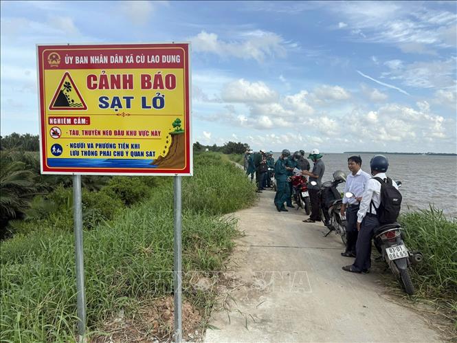 Biển cảnh báo nguy hiểm được dựng lên nhằm cấm tàu thuyền neo đậu, hạn chế tác động của sóng vào thân đê đang suy yếu. Ảnh: TTXVN phát