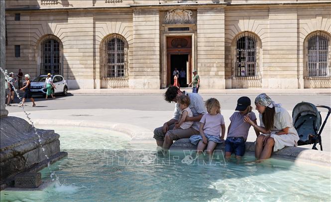 Người dân làm mát tại đài phun nước ở Arles, Pháp. Ảnh: THX/TTXVN phát