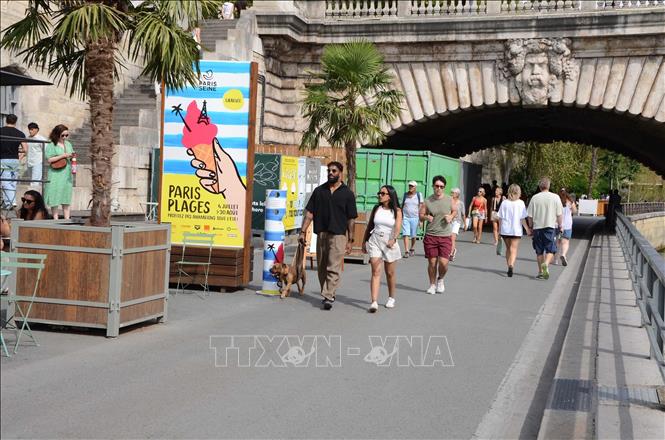 Biển giới thiệu sự kiện Paris Plages được đặt tại một trong các lối vào khu vực tổ chức bên bờ sông Seine, thu hút đông người dân và du khách tham quan. Ảnh: Hữu Chiến - PV TTXVN tại Pháp