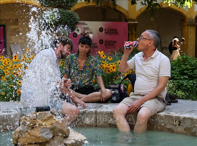 Người dân làm mát tại đài phun nước ở Arles, Pháp. Ảnh: THX/TTXVN phát