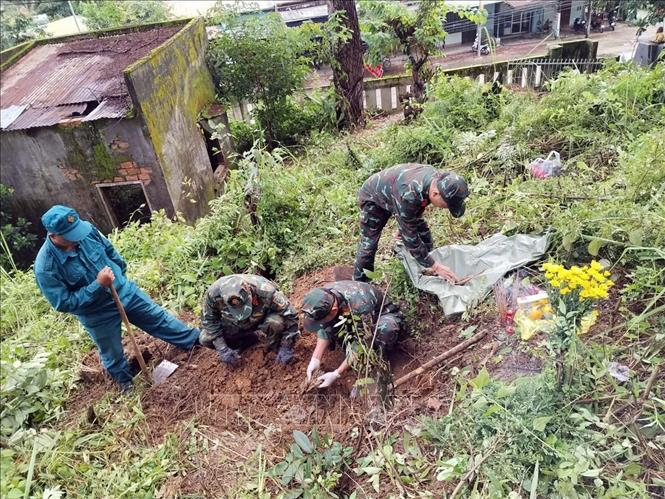 Lực lượng chức năng xã Đăk Pék tìm kiếm, đào đất quy tập hài cốt liệt sỹ tại thôn 15/6.
Ảnh: TTXVN phát