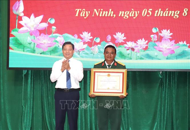 Phó Chủ tịch UBND tỉnh Tây Ninh Phạm Tấn Hoà thừa uỷ quyền Chủ tịch nước, trao tặng Huân chương Bảo vệ Tổ quốc hạng Ba cho Đại tá Trần Chí Công, Đội trưởng Đội K73. Ảnh: Đức Hạnh - TTXVN