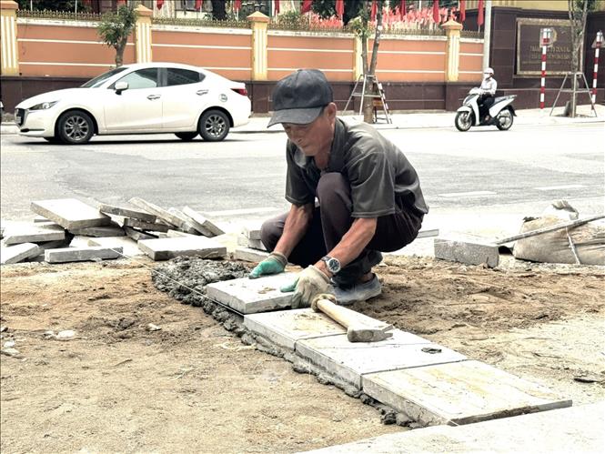 Công nhân nhà thầu tiến hành hoàn thiện phần nát vỉa hè trên đường Nguyễn Tuân (phường Thanh Xuân, thành phố Hà Nội. Ảnh: Quốc Lũy - TTXVN