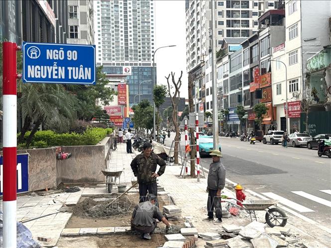 Công nhân nhà thầu tiến hành hoàn thiện phần nát vỉa hè trên đường Nguyễn Tuân (phường Thanh Xuân, thành phố Hà Nội. Ảnh: Quốc Lũy - TTXVN