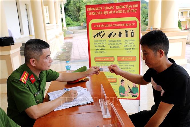 Lực lượng Công an phường trao bằng lái xe mô tô cho người dân. Ảnh: Thanh Hải - TTXVN  