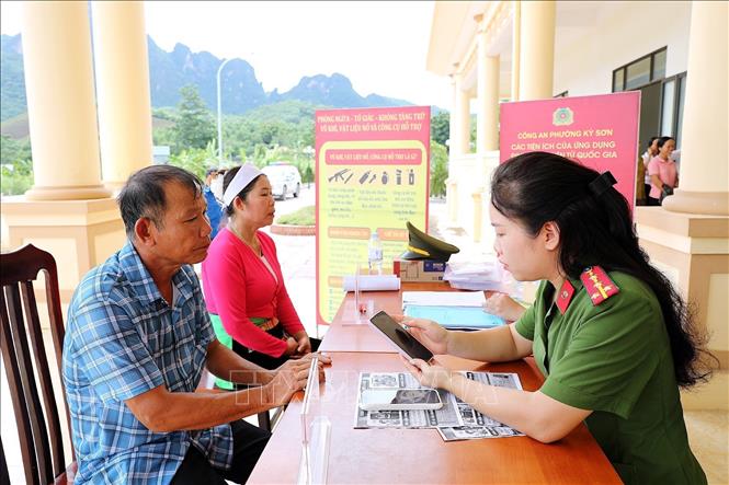 Lực lượng Công an phường hướng dẫn người dân sử dụng ứng VNeID. Ảnh: Thanh Hải - TTXVN 