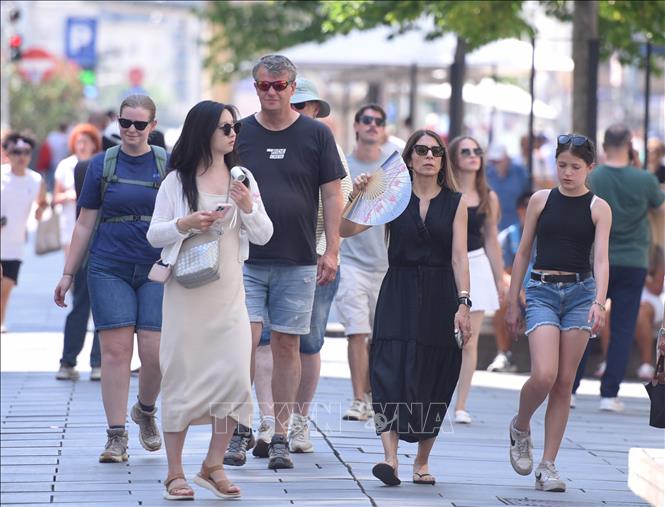 Người dân sử dụng quạt cầm tay khi di chuyển dưới trời nắng nóng ở thủ đô Vienna, Áo ngày 5/8/2026. Ảnh: THX/TTXVN phát