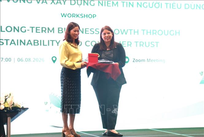 Đại diện Ủy ban Cạnh tranh Quốc gia tặng hoa cho đại diện tổ chức GIZ. Ảnh: Hương Giang - TTXVN
