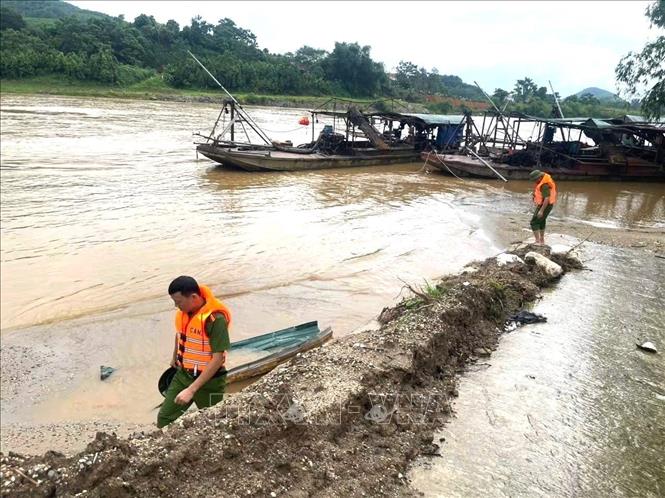 Các lực lượng chức năng rà soát khu vực ven sông và những vị trí có khả năng nạn nhân bị dòng nước cuốn trôi. Ảnh: Minh Tâm - TTXVN