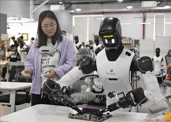 Nhân viên huấn luyện robot làm việc trên dây chuyền sản xuất, tại thành phố Thượng Hải, miền Đông Trung Quốc. Ảnh: THX/TTXVN phát
