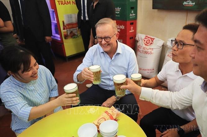 Thủ tướng Australia Anthony Albanese thưởng thức món bánh mỳ patê truyền thống, uống bia hơi Hà Nội tại một quán ăn trên phố Đường Thành, quận Hoàn Kiếm, Hà Nội. Ảnh: Lâm Khánh – TTXVN