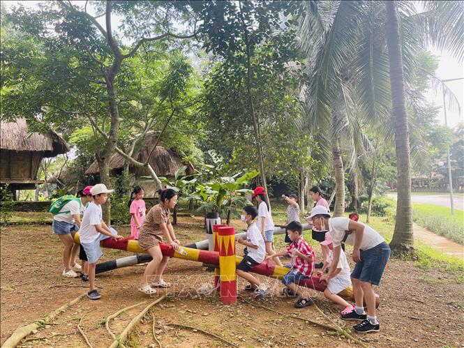 Các em nhỏ trải nghiệm trò chơi dân gian trong không gian văn hóa Tây Nguyên tại Làng Văn hóa - Du lịch các dân tộc Việt Nam. Ảnh: Tuyết Mai - TTXVN