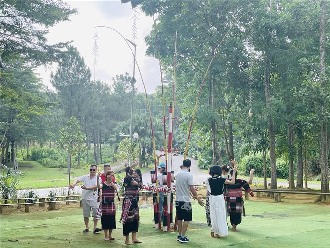 Du khách trải nghiệm điệu múa truyền thống cùng các cô gái Ba Na tại không gian làng dân tộc Ba Na, Làng Văn hóa - Du lịch các dân tộc Việt Nam. Ảnh: Tuyết Mai - TTXVN