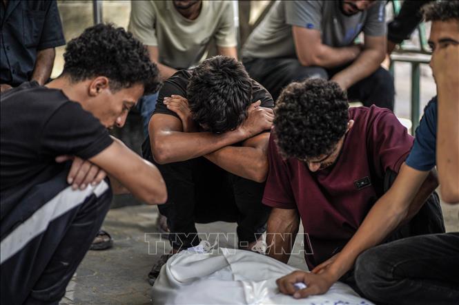 Người Palestine đau buồn bên thi thể các nạn nhân sau một cuộc không kích của Israel, tại Bệnh viện Al-Shifa ở thành phố Gaza. Ảnh: THX/TTXVN phát