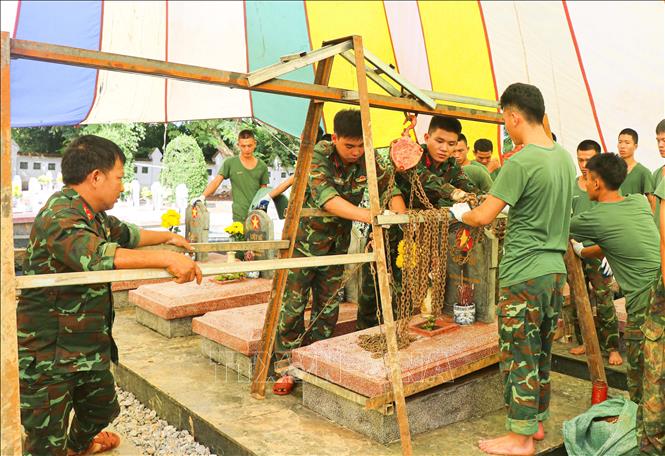 Các cán bộ, chiến sĩ Bộ Chỉ huy Quân sự tỉnh Điện Biên dùng Ba lăng xích để di dời các phần mộ, Giải pháp này góp phần rút ngắn thời gian thi công, giảm sức lao động, nâng cao độ an toàn và hạn chế tối đa ảnh hưởng đến hiện trạng phần mộ trong quá trình khai quật, hoàn nguyên. Ảnh: Phan Quân - TTXVN