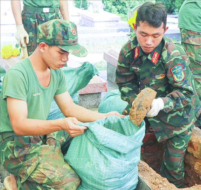 Các chiến sĩ Trung đoàn 741 (Bộ Chỉ huy Quân sự tỉnh Điện Biên) đào đất, cất bốc các phần mộ tại Nghĩa trang Liệt sĩ Độc Lập, xã Thanh Nưa. Ảnh: Phan Quân - TTXVN