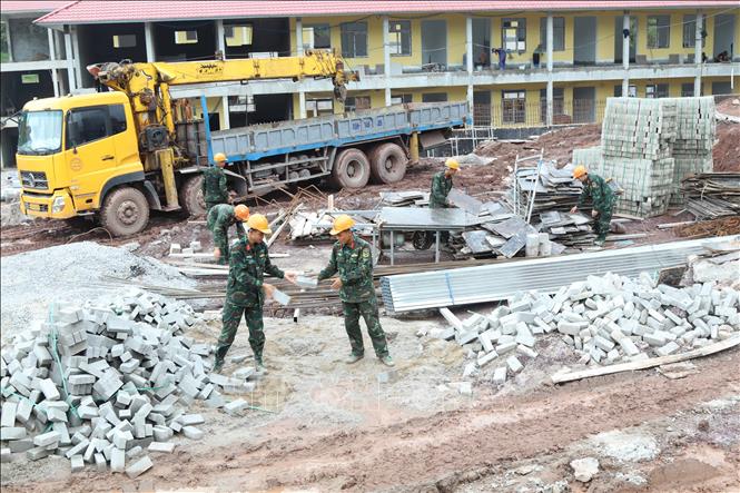 Lực lượng quân đội hỗ trợ vận chuyển vật tư xây dựng Trường phổ thông nội trú liên cấp xã biên giới Kiên Mộc (Lạng Sơn). Ảnh: Quang Duy – TTXVN