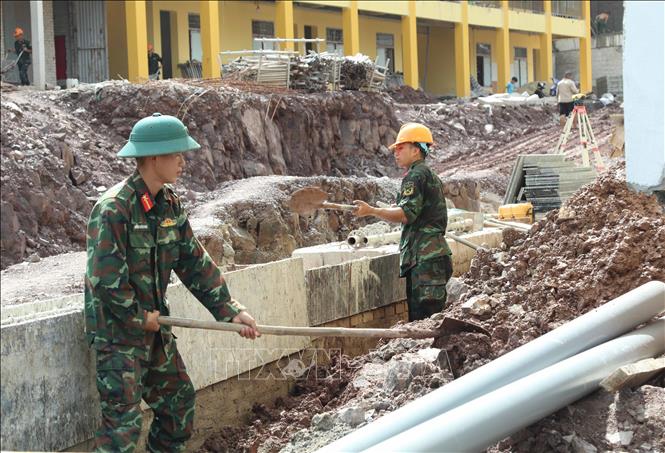 Lực lượng quân đội tham gia hỗ trợ đào đắp nền Trường phổ thông nội trú liên cấp xã biên giới Kiên Mộc (Lạng Sơn). Ảnh: Quang Duy – TTXVN