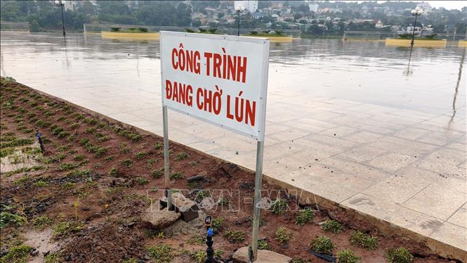 Chủ đầu tư đặt biển công trình đang chờ lún. Ảnh: Hưng Thịnh – TTXVN