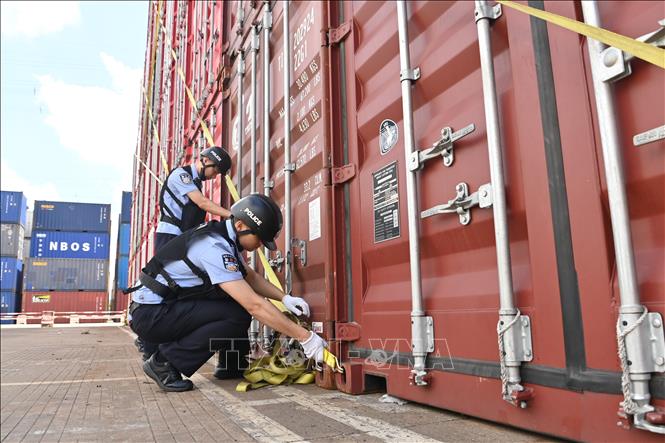 Nhân viên an ninh thực hiện biện pháp bảo vệ các container hàng hóa tại bãi container ở thành phố Ninh Ba, tỉnh Chiết Giang, miền Đông Trung Quốc trước khả năng bão Dolphin đổ bộ, ngày 7/8/2026. Ảnh: THX/TTXVN phát 