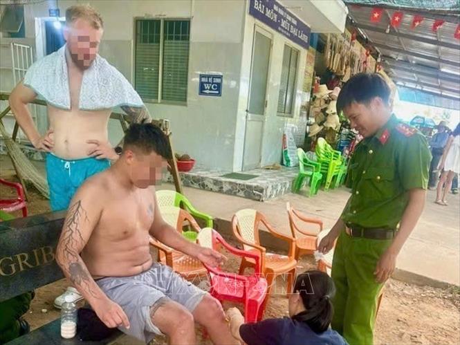 Lực lượng chức năng hỗ trợ các du khách vào bờ an toàn khi bị kẹt tại mõm đá ở Bãi Môn (xã Hòa Xuân). Ảnh: TTXVN phát