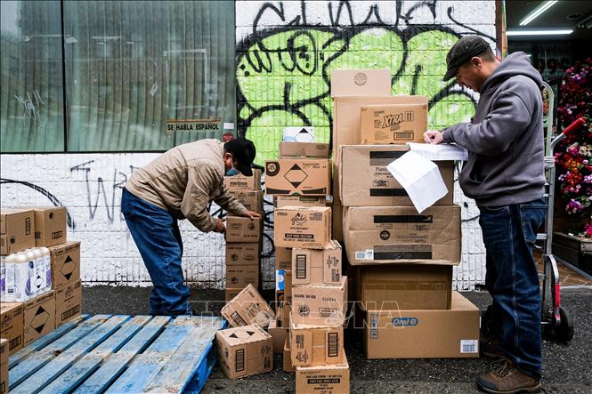 Công nhân bốc dỡ hàng hóa tại một cửa hàng ở New York, Mỹ. Ảnh: THX/TTXVN phát