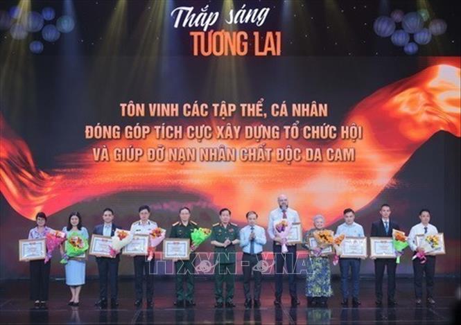 Ủy viên TƯ Đảng, Phó trưởng Ban thường trực Ban Dân vận Trung ương Phạm Tất Thắng và Trung tướng Nguyễn Hữu Chính, Chủ tịch Hội Nạn nhân chất độc da cam/dioxin Việt Nam với các tổ chức, cá nhân có nhiều đóng góp tích cực giúp đỡ nạn nhân chất độc da cam/dioxin. Ảnh: Hoàng Hiếu - TTXVN