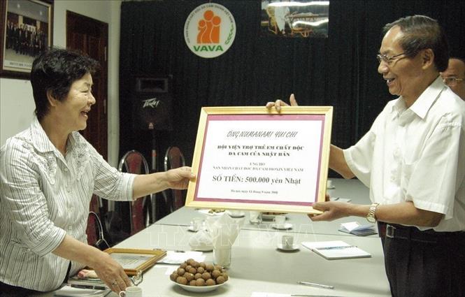 Đại diện Hội Nạn nhân chất độc da cam/dioxin Việt Nam (bên phải) tiếp nhận số tiền 500.000 yên Nhật của ông Numanamin Yuichi ủng hộ các nạn nhân chất độc da cam/dioxin Việt Nam thông qua Hội viện trợ trẻ em chất độc da cam của Nhật (11/9/2008). Ảnh: Dương Ngọc - TTXVN