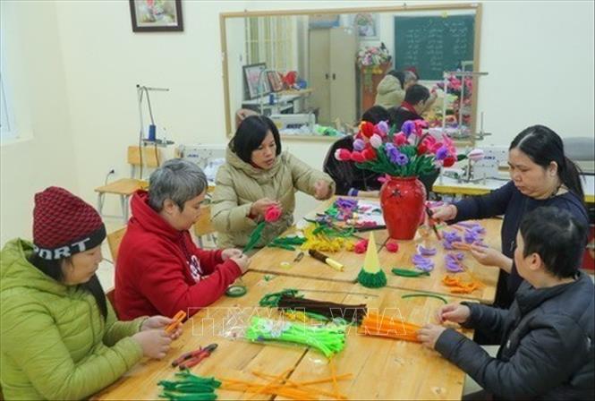 Cán bộ Trung tâm Chăm sóc nuôi dưỡng và Điều trị nạn nhân bị nhiễm chất độc da cam/dioxin Hà Nội luôn quan tâm việc hướng nghiệp, lao động trị liệu cho các bệnh nhân. Ảnh: Hoàng Hiếu - TTXVN