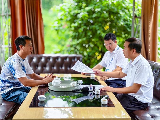 Ông Nguyễn Văn Toàn, Phó Chủ tịch UBND xã Kim Anh, Hà Nội (bên phải), trao đổi với đại diện cơ sở trong quá trình kiểm tra, xác minh hiện trạng sử dụng đất và xây dựng tại khu vực rừng phòng hộ Sóc Sơn. Ảnh: Trung Nguyên - TTXVN