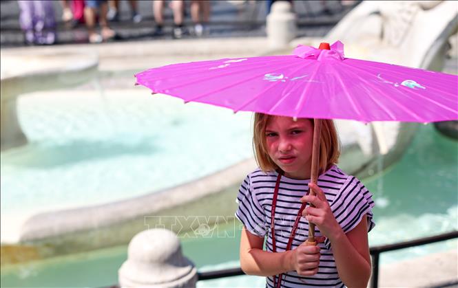 Em nhỏ che ô tránh nắng trên Quảng trường Piazza di Spagna ở Rome, Italy,    ngày 10/7/2026. Ảnh: THX/TTXVN phát