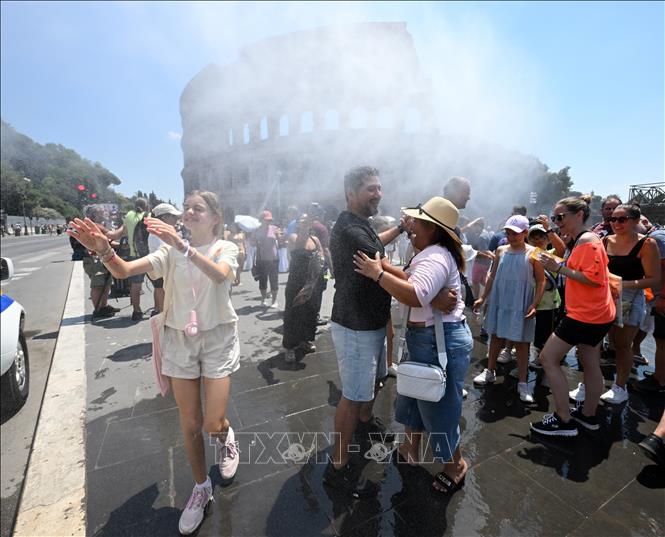 Người dân làm mát dưới hệ thống phun sương gần đấu trường Colosseum khi nắng nóng gay gắt tại Rome, Italy, ngày 26/6/2026. Ảnh: THX/TTXVN phát