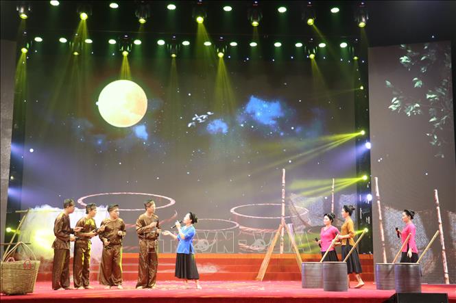 Bối cảnh làng nghề truyền thống kết hợp ánh sáng hiện đại tạo nên chiều sâu không gian cho tiết mục dân ca Ví, Giặm. Ảnh: Hoàng Ngà - TTXVN