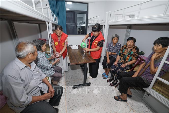 Tình nguyện viên hỗ trợ người dân tại một điểm sơ tán tránh bão tạm thời ở  thành phố Kim Hoa, tỉnh Chiết Giang, miền Đông Trung Quốc, ngày 8/8/2026. Ảnh: THX/TTXVN phát