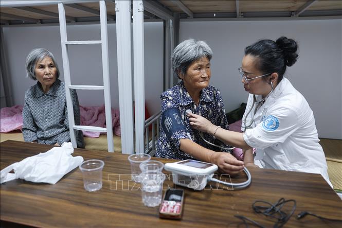 Bác sĩ khám sức khỏe cho người dân tại điểm sơ tán tránh bão tạm thời ở thành phố Kim Hoa, tỉnh Chiết Giang, miền Đông Trung Quốc, ngày 8/8/2026. Ảnh: THX/TTXVN phát