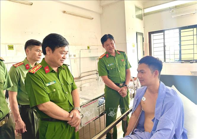 Đại tá Lê Đức Bảy, Phó Giám đốc Công an thành phố Cần Thơ thăm, động viên Thượng úy Trần Ngọc Lợi.Ảnh: Nguyễn Văn Việt-TTXVN