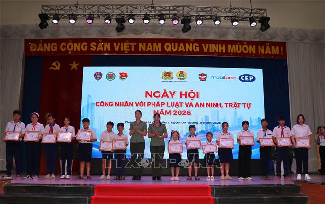 Đại diện Công an Thành phố Hồ Chí Minh tặng học bổng cho con công nhân có hoàn cảnh khó khăn tại ngày hội,Ảnh: Thanh Vũ - TTXVN
