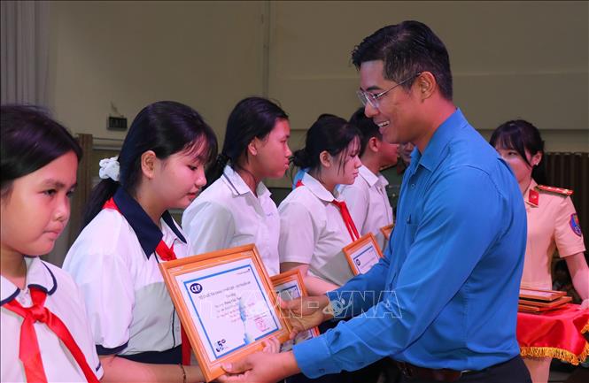 Đại diện Liên đoàn Lao động Thành phố Hồ Chí Minh tặng học bổng cho con công nhân có hoàn cảnh khó khăn tại ngày hội,Ảnh: Thanh Vũ - TTXVN
