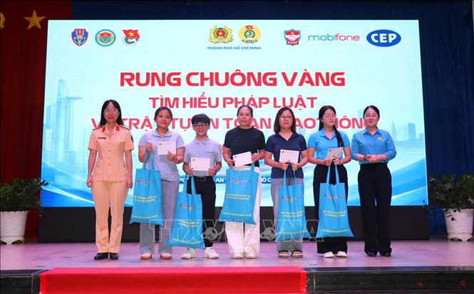 Lãnh đạo Liên đoàn Lao động Thành phố Hồ Chí Minh cùng Công an Thành phố tặng quà cho công nhân tham gia tuyên truyền về an toàn giao thông tại ngày hội,Ảnh: Thanh Vũ - TTXVN

