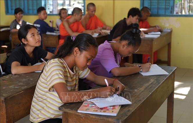 Các bạn nhỏ tập viết chữ dưới mái chùa Prum Visal. Ảnh: Nguyễn Hằng - TTXVN
