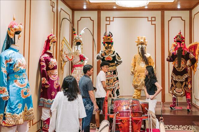 Khán giả tham quan không gian giới thiệu phục trang, đạo cụ và tạo hình nhân vật Tuồng trước giờ diễn, từ đó có thêm cơ hội tiếp cận những lớp giá trị nằm phía sau một tác phẩm sân khấu truyền thống. Ảnh: Phạm Tuấn Anh - TTXVN