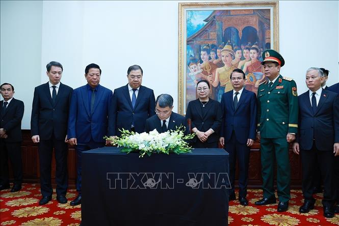 Prime Minister Le Minh Hung writes in the book of condolences. VNA Photo: Dương Giang 