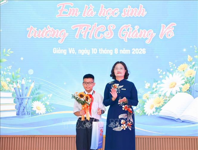 Nhà giáo Tô Thị Hải Yến, Hiệu trưởng Trường THCS Giảng Võ tặng quà và gửi lời căn dặn tới học sinh khối 6. Ảnh: Thanh Tùng – TTXVN