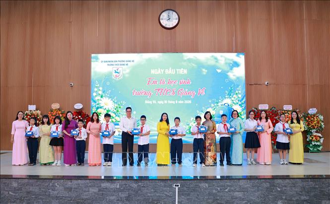 Các thầy cô chủ nhiệm khối 6 của Trường THCS Giảng Võ ra mắt và tặng quà cho học sinh.  Ảnh: Thanh Tùng – TTXVN