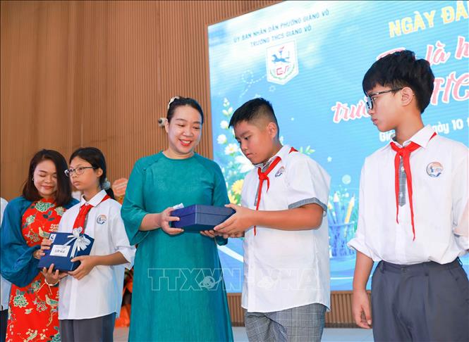 Các thầy cô chủ nhiệm khối 6 của Trường THCS Giảng Võ ra mắt và tặng quà cho học sinh.  Ảnh: Thanh Tùng – TTXVN