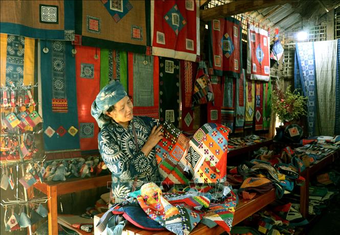 Bà Vàng Thị Mai, Giám đốc Hợp tác xã Lanh Lùng Tám (Tuyên Quang), giới thiệu các sản phẩm dệt lanh truyền thống của đồng bào Mông. Ảnh: Đức Thọ - TTXVN