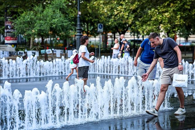 Người dân tránh nóng tại đài phun nước ở Budapest, Hungary. Ảnh: THX/TTXVN phát