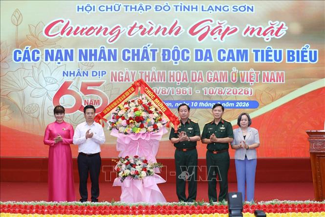 Trung tướng Nguyễn Hữu Chính, Chủ tịch Hội Nạn nhân chất độc da cam/dioxin Việt Nam tặng hoa Ban tổ chức tổ chức Chương trình. Ảnh: Anh Tuấn – TTXVN