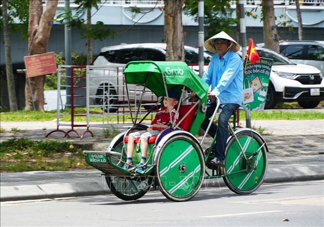 Người đạp xích lô trên đường Lê Duẩn, thành phố Huế đội nón rộng vành để giảm tác động nắng nóng. Ảnh: Nguyên Lý - TTXVN