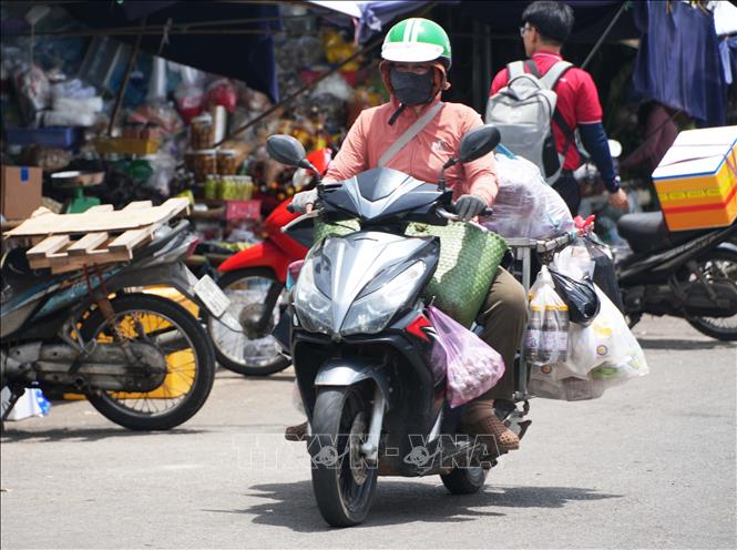 Vất vả vận chuyển hàng hóa trên đường Chương Dương - chợ Đông Ba, thành phố Huế dưới trời nắng nóng. Ảnh: Nguyên Lý - TTXVN